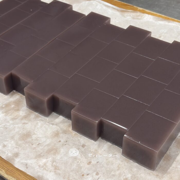 仕込み中の水ようかん、切り分けられた小豆色の一枚シート